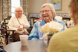 Smiling seniors chatting at community center table