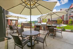 Outdoor patio with tables, umbrellas, and grill