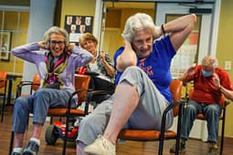 Seniors doing seated exercise class indoors