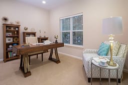 Modern home office with wooden desk and armchair