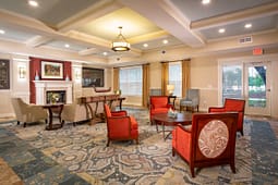 Cozy lobby lounge with red chairs and fireplace