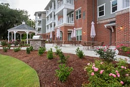 Apartment patio with gazebo, grill, and seating