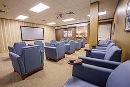 Small theater room with blue armchairs and projector screen