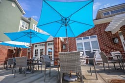 Outdoor patio with blue umbrellas and wicker chairs