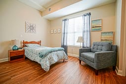 Cozy bedroom with single bed and gray armchair