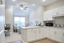 Modern white kitchen opening to cozy living area