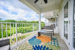 Modern balcony with wicker seating and colorful rug