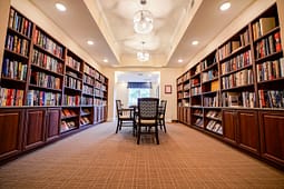 Cozy library room with wooden bookshelves and table