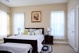 Bright bedroom with wooden bed and white bedding
