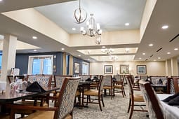 Elegant restaurant dining room with chandeliers and patterned chairs