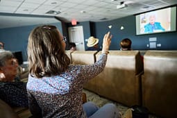 Woman raises hand during community presentation