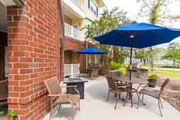 Outdoor patio with tables, chairs, and blue umbrellas