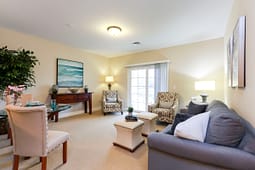 Bright staged living room with sofa and armchairs