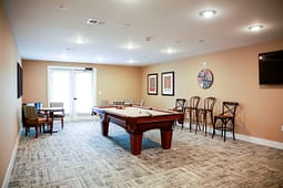 Community game room with pool table and seating