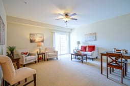 Bright staged living room with sofa and chairs