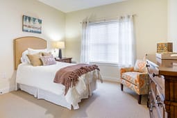 Cozy bedroom with bed, window, and armchair