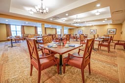 Spacious dining room with set tables and upholstered chairs
