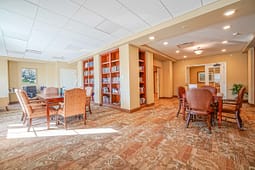 Cozy community library room with tables and bookshelves