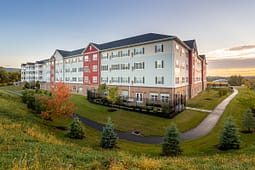 Modern apartment building at sunset with landscaped grounds
