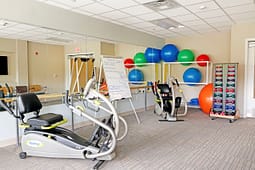 Small fitness room with cardio machines and weights