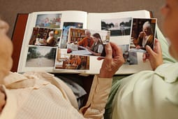 Elderly woman looking through family photo album