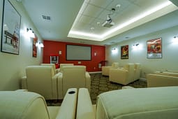 Cozy home theater with cream chairs and projector