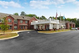 Brick apartment building with covered entrance and flags