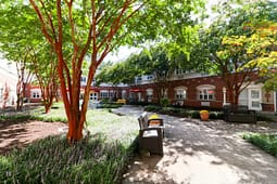 Shaded courtyard with benches and brick building