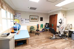 Physical therapy room with exercise equipment and table