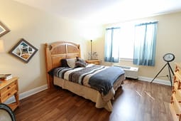 Bright bedroom with wooden bed and blue curtains