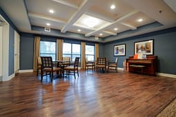 Spacious community room with piano and seating