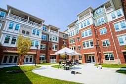 Modern apartment courtyard with patio seating and umbrella