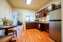 Modern apartment kitchen with dark cabinets and hardwood floors