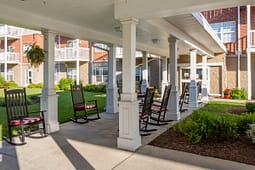 Covered porch with rocking chairs and courtyard