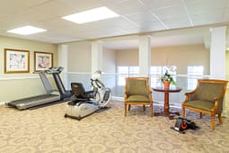 Small fitness room with treadmill and chairs
