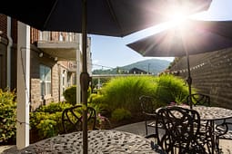 Sunlit patio with umbrellas and mountain view