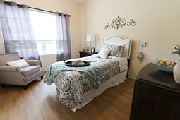 Cozy bedroom with patterned bedding and armchair
