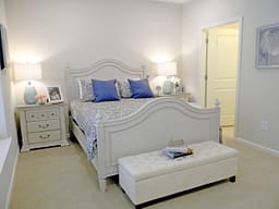 Bright white bedroom with blue accent pillows