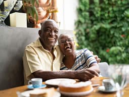Elderly couple laughing together at café table
