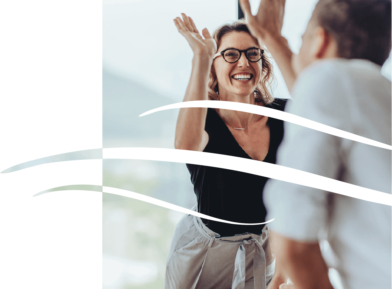 Smiling woman high-fiving colleague indoors