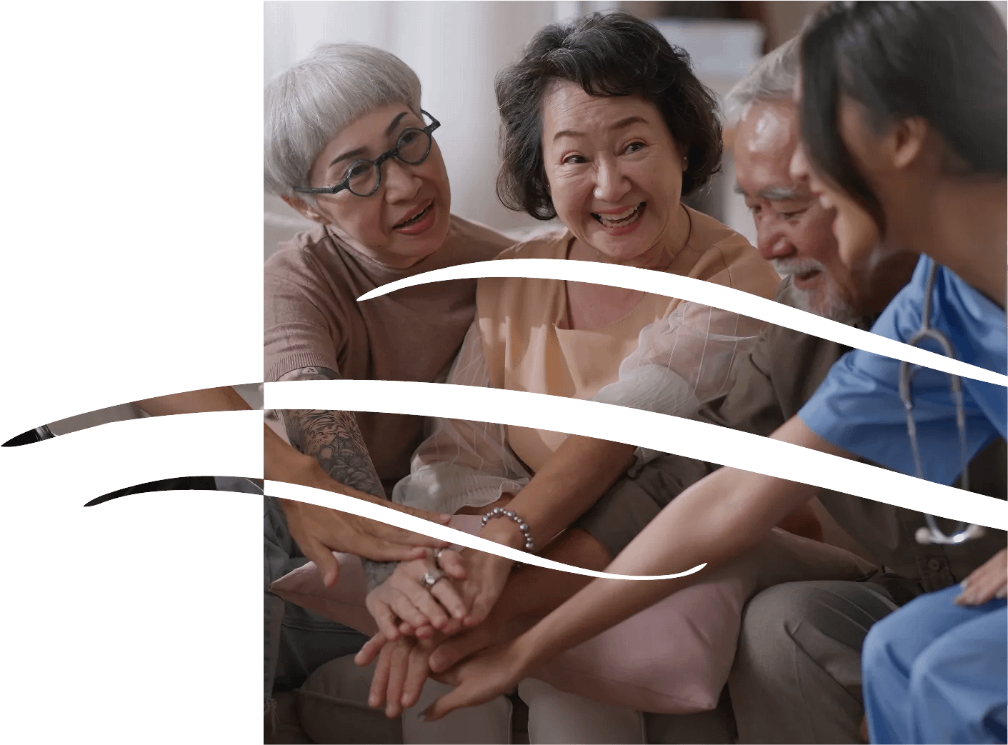 Smiling seniors and nurse stacking hands together