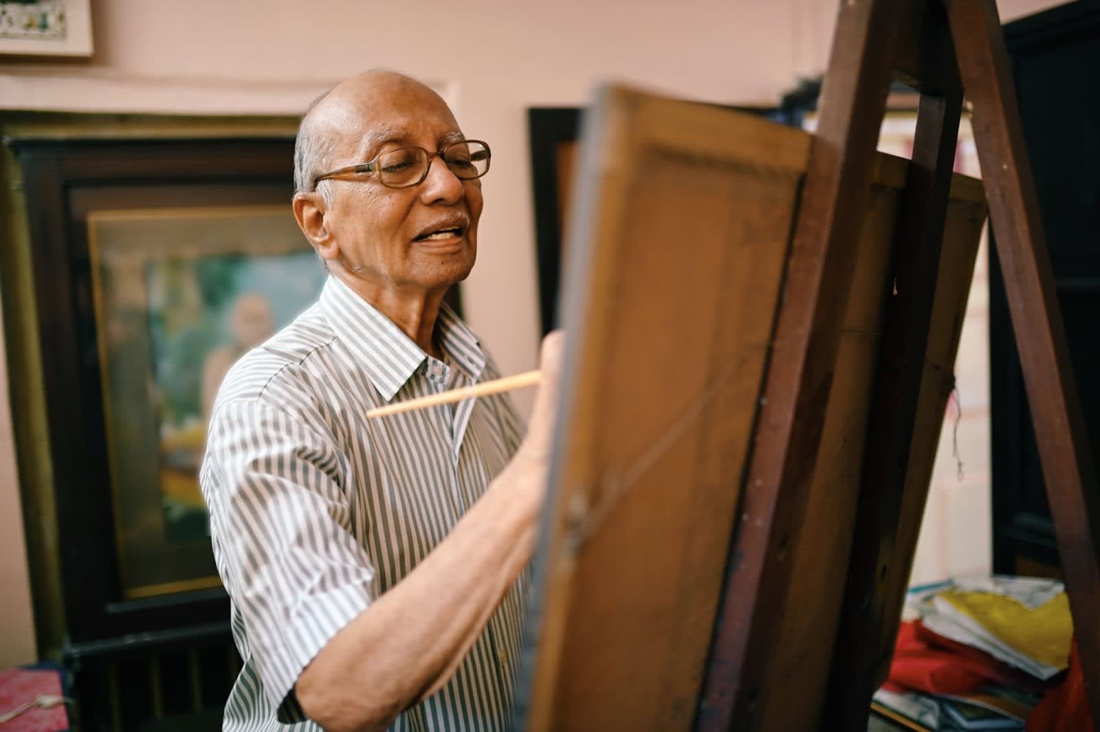 Older man painting on an easel