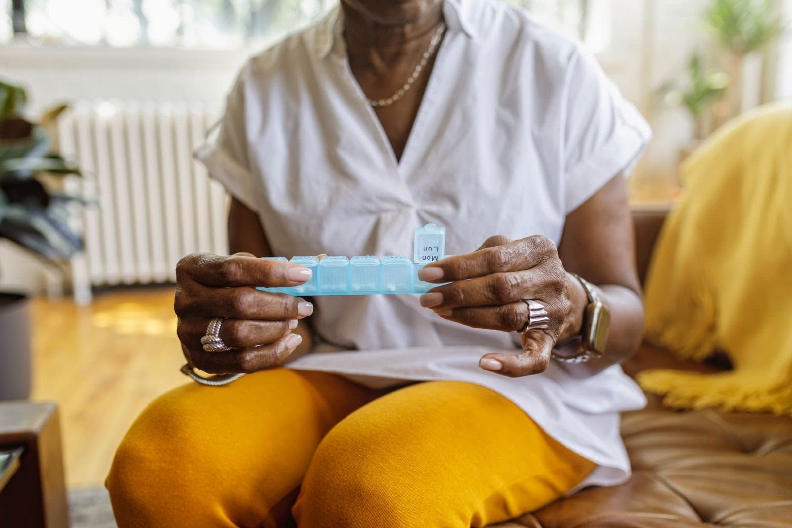 Senior woman opening up a pill organizer