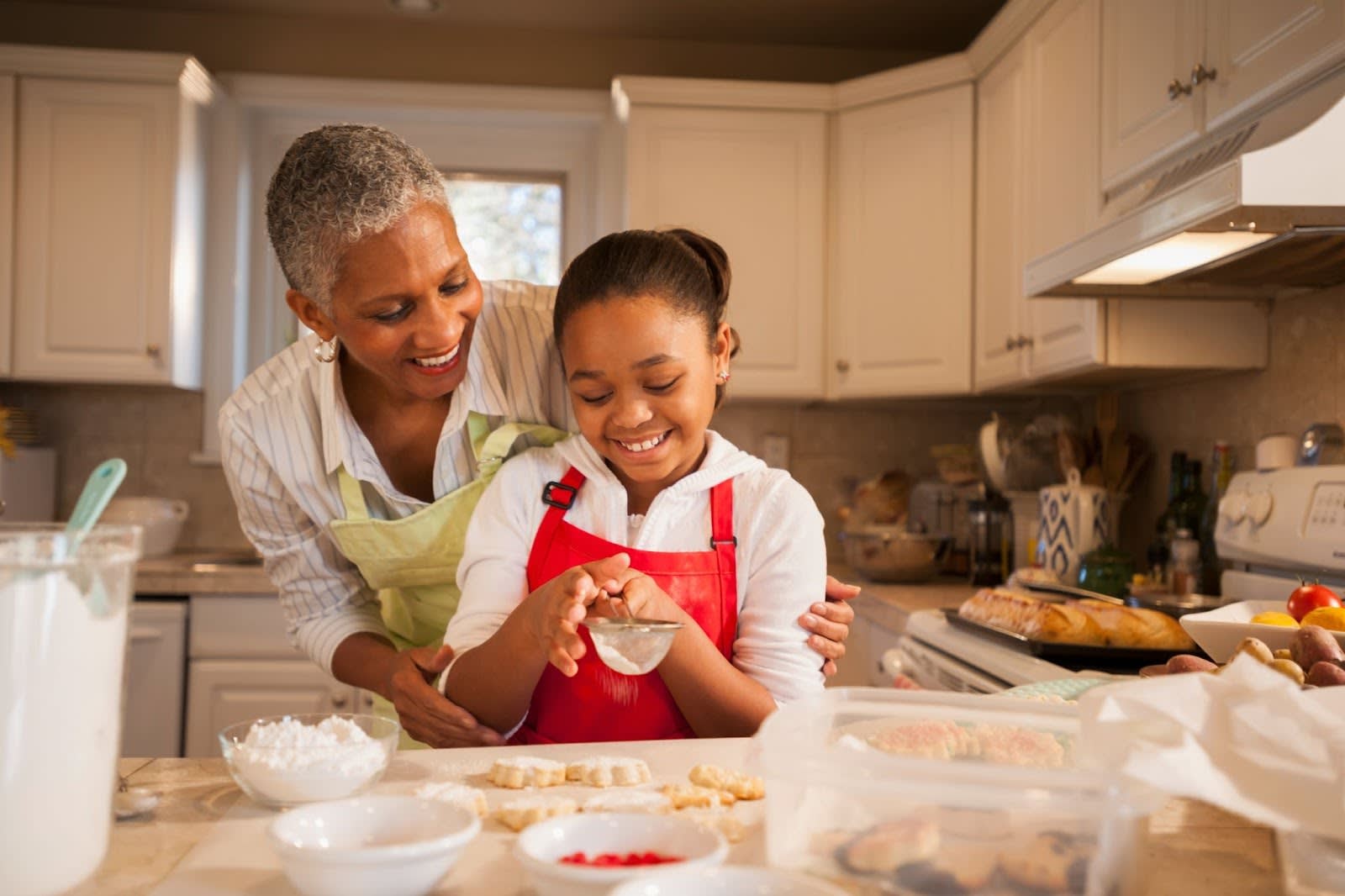 Older woman and young girl baking cookies in a kitchen
