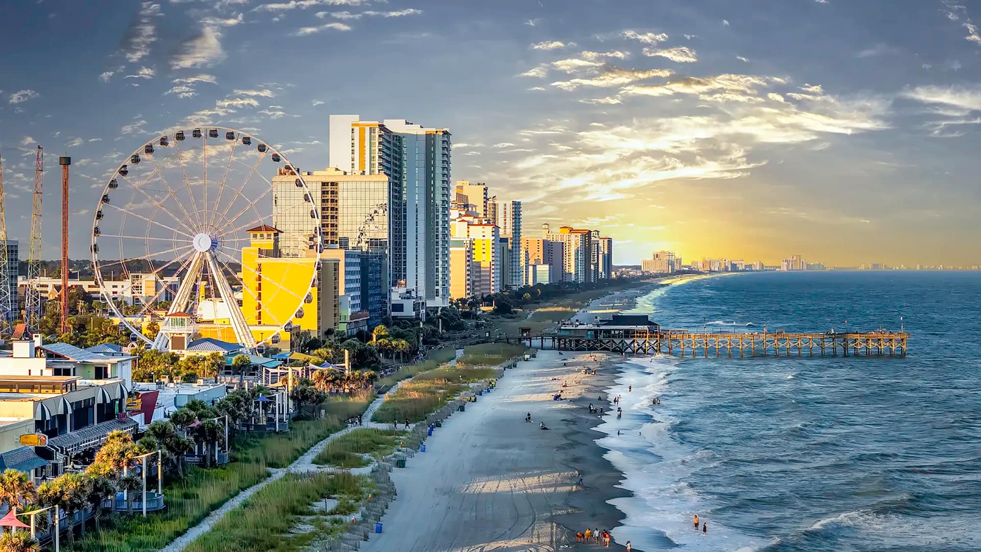Beachfront skyline with Ferris wheel at sunset