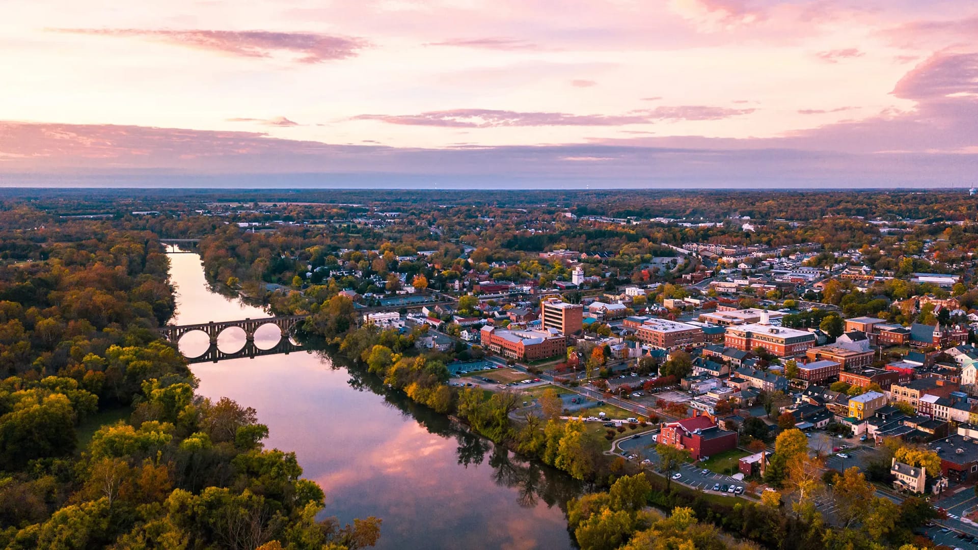 Aerial view of town, river, and arched bridge