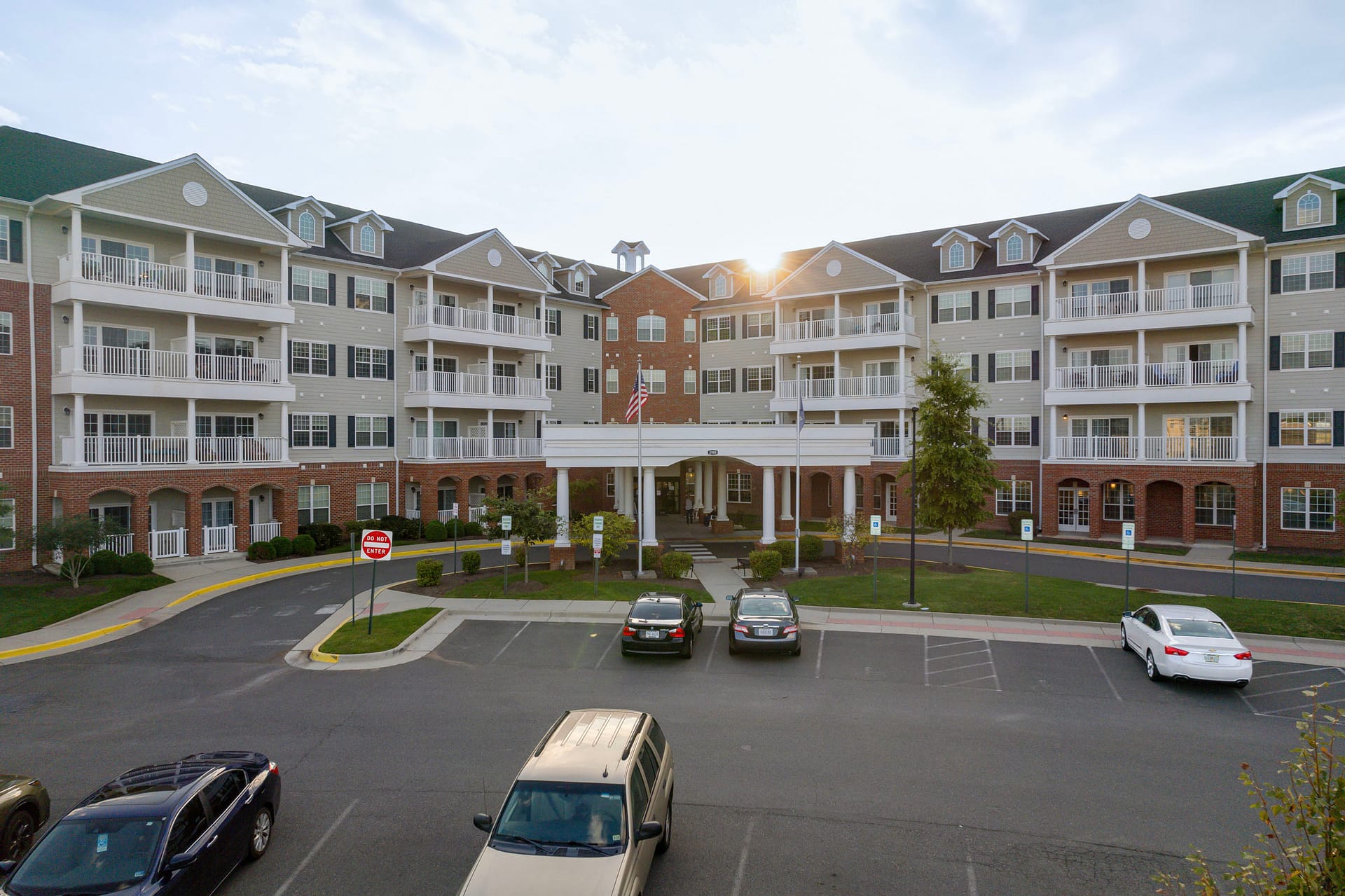 Large apartment building with parking lot at sunset