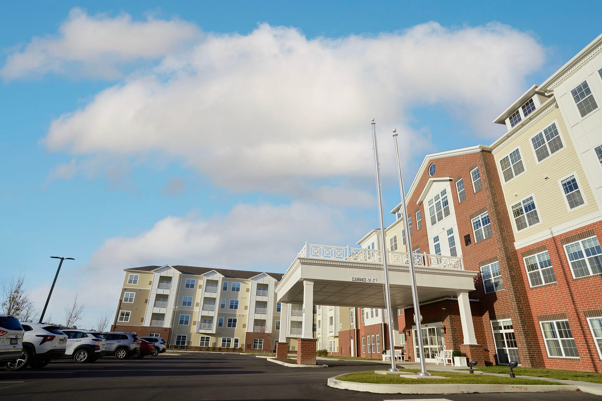 Modern apartment complex with covered entrance and parking