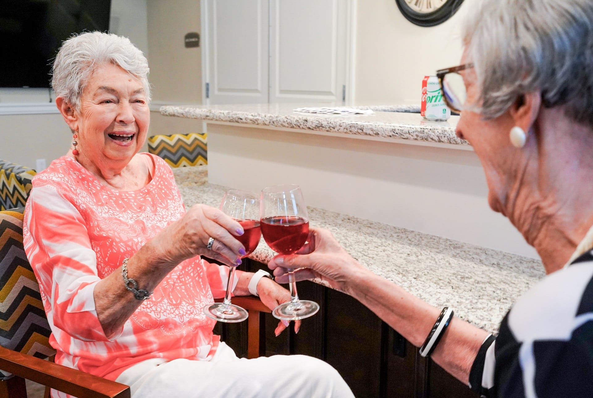 Two elderly women toasting with red wine