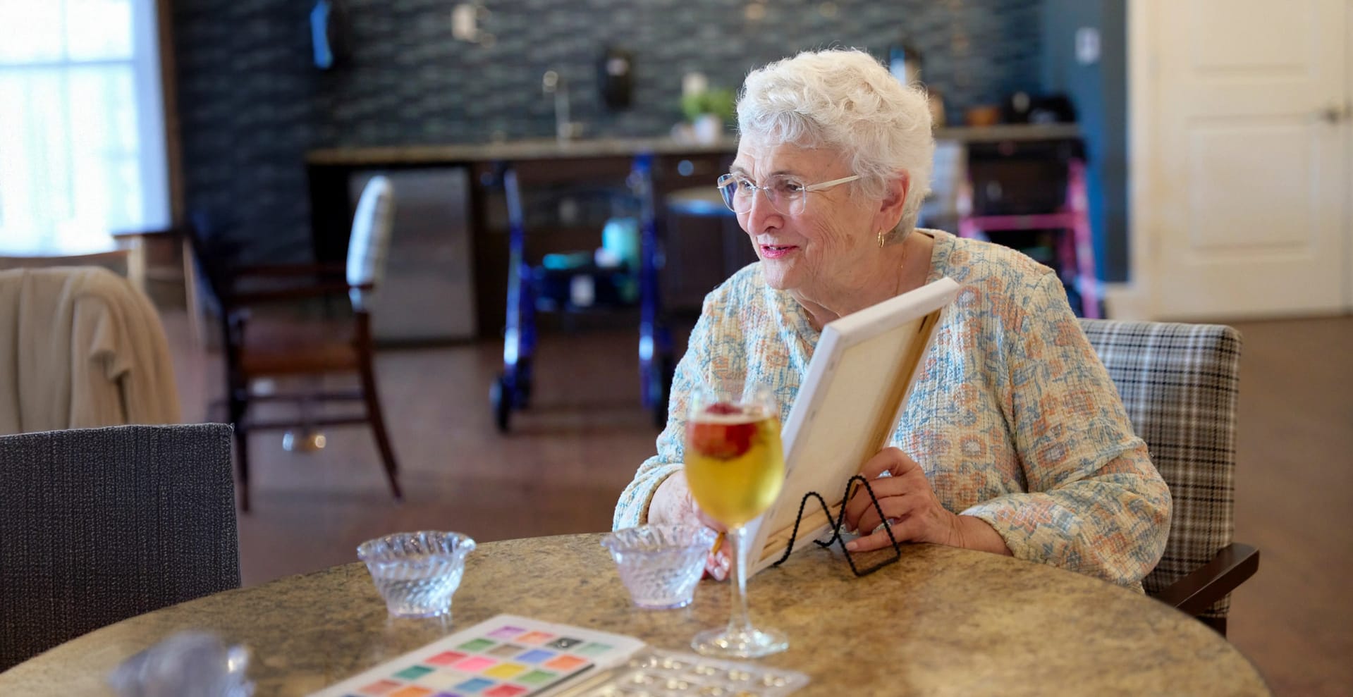 Elderly woman holding framed photo at table
